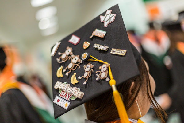Yuetong Hao MS Finance student graduating with mortarboard decorated with characters representing her birth during the Year of the Monkey and with Texas-themed decorations. She earned a master's degree in finance.