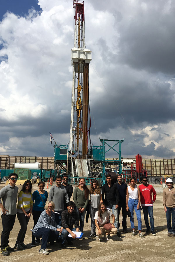 Master's in Energy Management students in front of gas-drilling equipment at a site visit