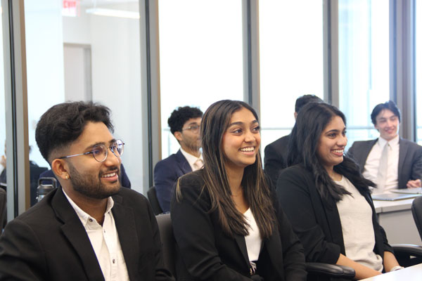 UT Dallas Professional Program in Finance students listen to a presentation in professional attire.