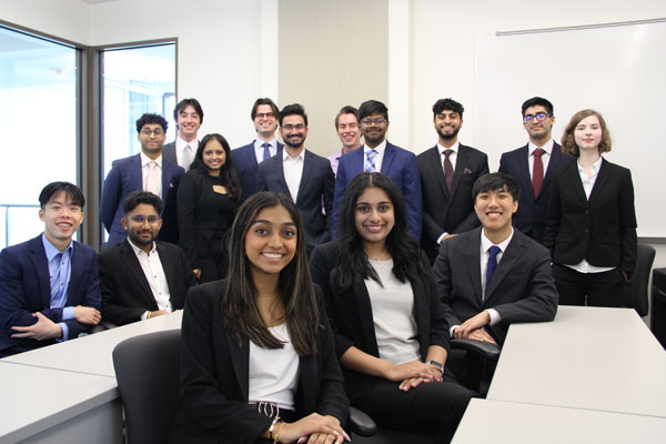 Students at the UT Dallas Professional Program in Finance meet together in professional attire.